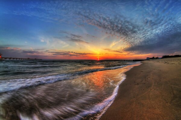 The sea tide on the background of sunset