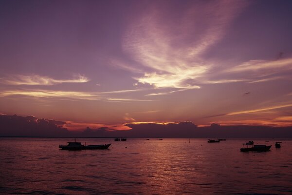 Pôr do sol roxo-carmesim. Barcos e navios no mar