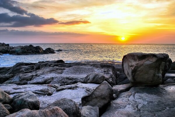 Costa rochosa do mar ao pôr do sol