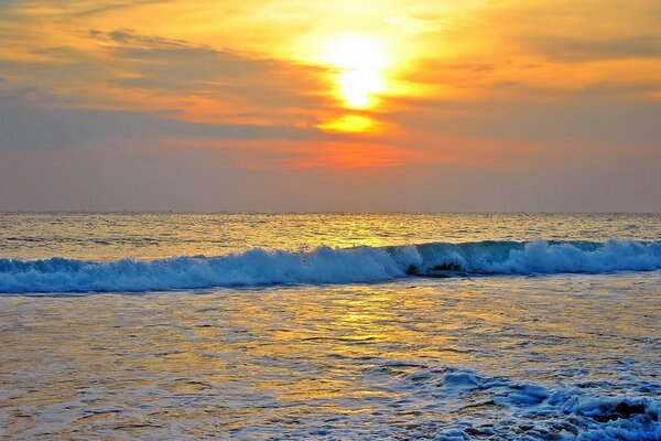 Puesta de sol sobre las olas del mar de espuma