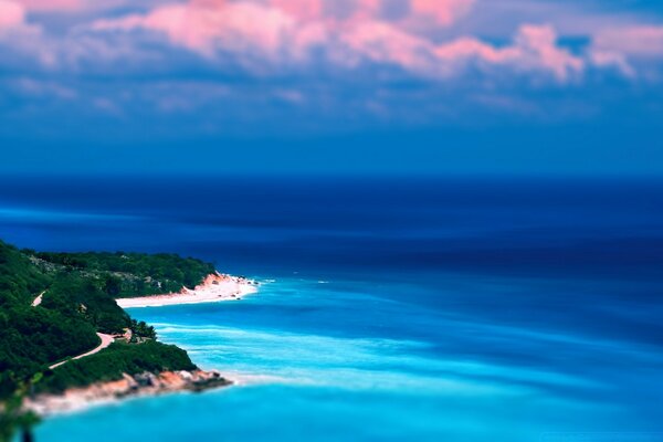 Isola paradisiaca nel mare sotto il cielo blu con nuvole rosa