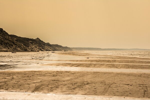 Spiaggia deserta sul mare con costa rocciosa