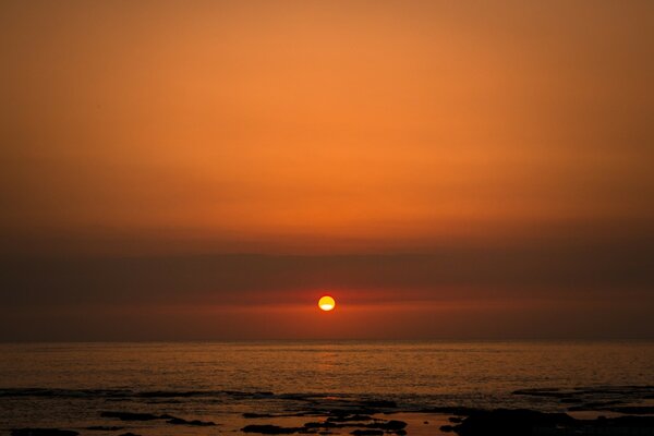 Pôr do sol sobre o mar calmo, o sol se põe no oceano