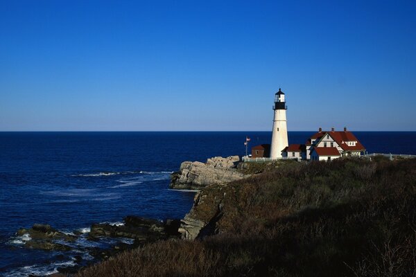 A lonely lighthouse on the background of the ocean and sky