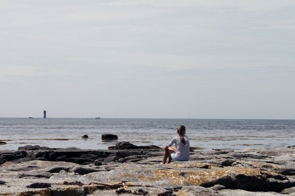 Fille regardant le phare dans l océan