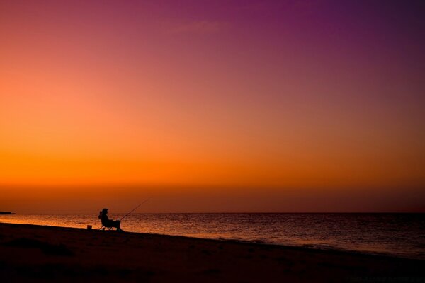 Bord de mer et coucher de soleil. Homme sur le rivage