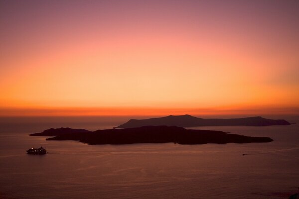 Dawn over an island in a dark ocean