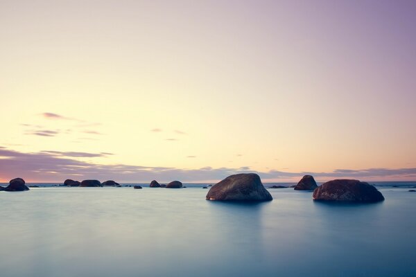 The pink sky is reflected in the ocean