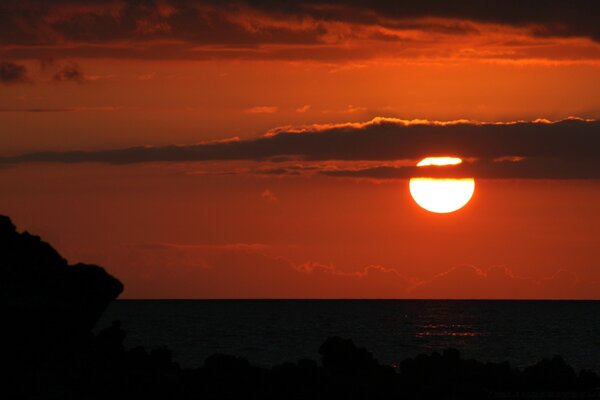 Sonnenuntergang bei Vollmond. der Mond hinter den Wolken