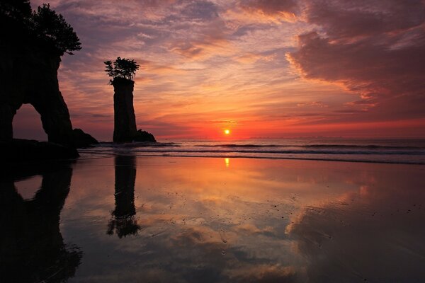 Der Sonnenuntergang am Meer spiegelt sich schön im Wasser wider