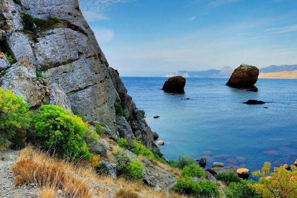 Montañas rocas en el agua horizonte cielo verde