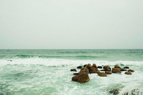 The waves of the ocean are beating against the rocks