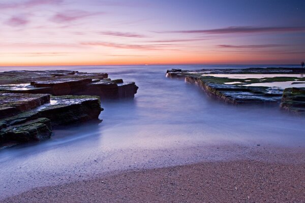 Mer brumeuse et roches grises froides