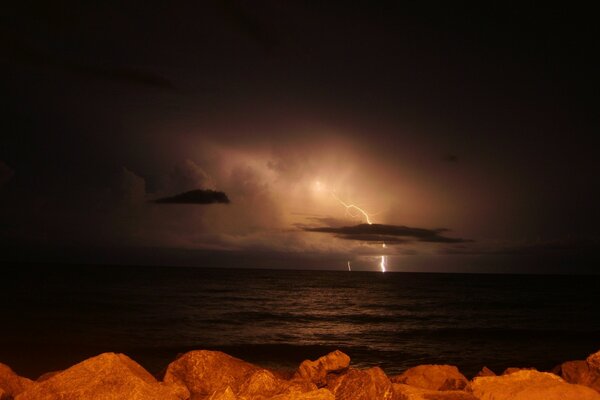 Stones at sunset on the background of lightning