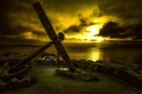 Anchor left on the seashore with sunset