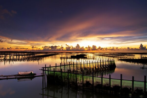 Tramonto e riflesso dell acqua nell oceano con recinzioni