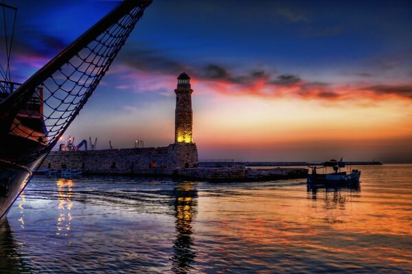 Sonnenuntergang und Leuchtturm spiegeln sich im Meer wider