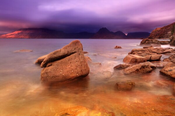 Puesta de sol sobre las rocas y el mar