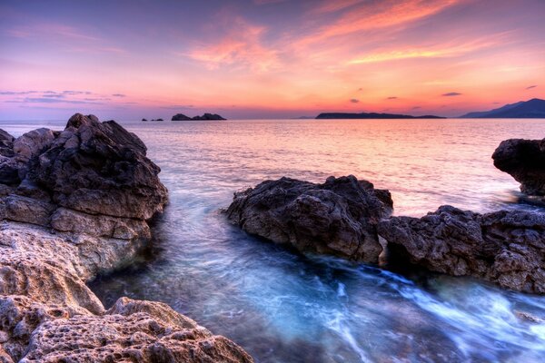 Tramonto rosa sull oceano e rocce 