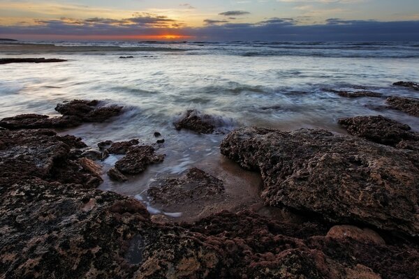 Spiaggia rocciosa dell Oceano ai raggi del tramonto