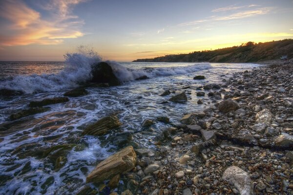 Pebble beach on the sea at sunset