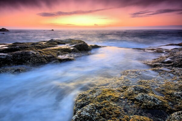 O anoitecer das rochas sobre as águas do oceano