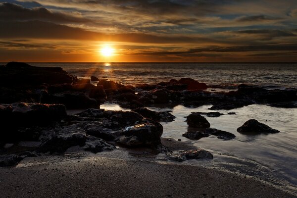 Sunset on the rocky ocean shore