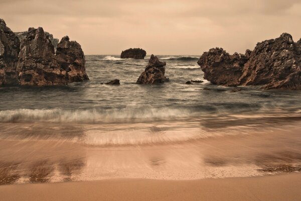 Seashore with outgoing water and rocks