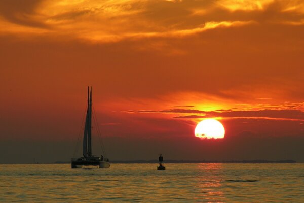 Boat in the ocean on the background of sunset