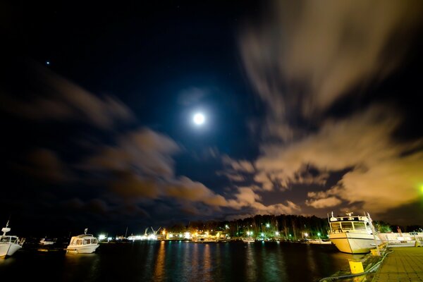 The moon illuminates the water at the pier