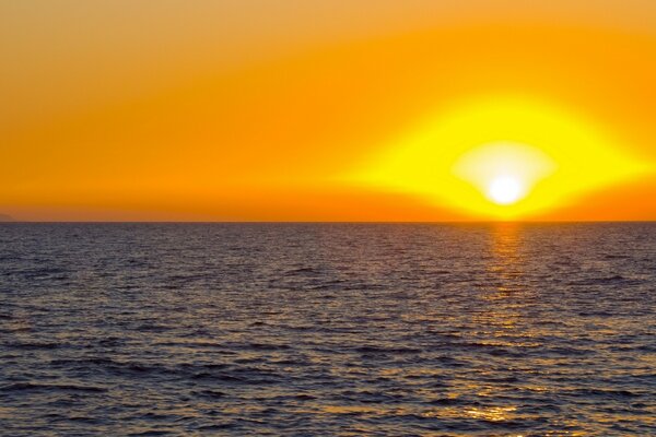 Orange Sonnenuntergang über der ruhigen Wasseroberfläche