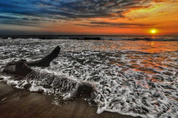 Imagem das ondas do mar em uma praia escura