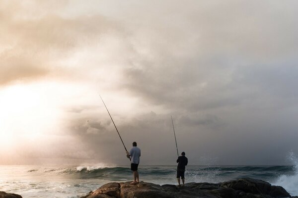 Los pescadores pescan en la orilla del mar