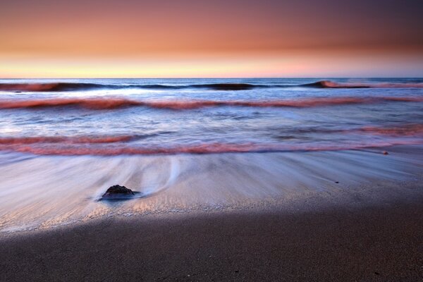 Low tide on a sandy beach and sunset