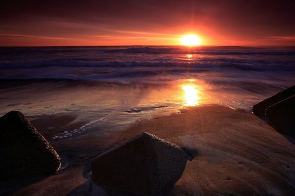 The sea waves are beating against the rocks at dawn