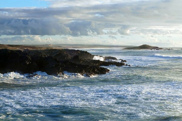 The sea surf beats against the rocks