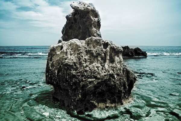 Roca solitaria en la orilla del mar