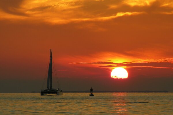 Sailboat on the waves in the sunset