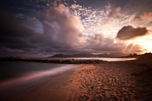 Sandy beach on the background of sunset