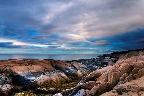 Interesante hermoso cielo sobre el mar y las rocas