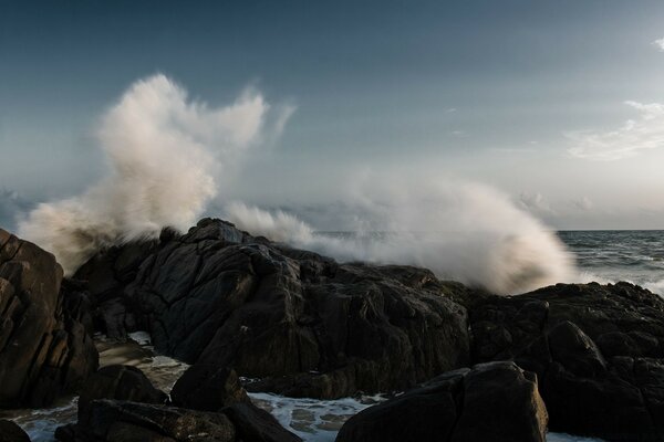 Sea waves break on the rocks with a lot of spray