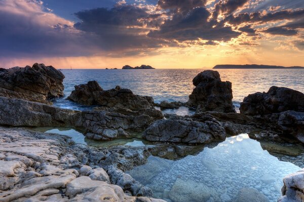 Mer et océan. Pierres et coucher de soleil