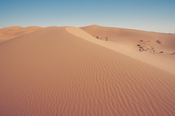 Dünen aus Sand unter blauem Himmel