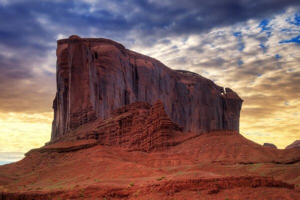 A large stone mountain against a cloudy sky