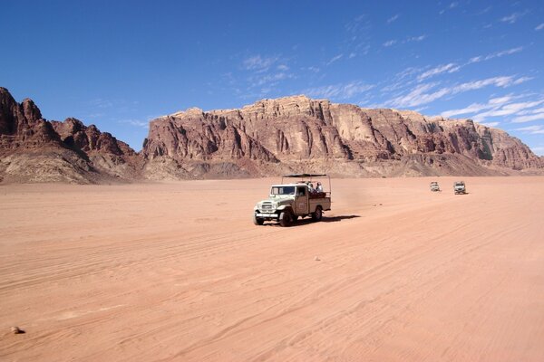 Carro no deserto no fundo das montanhas