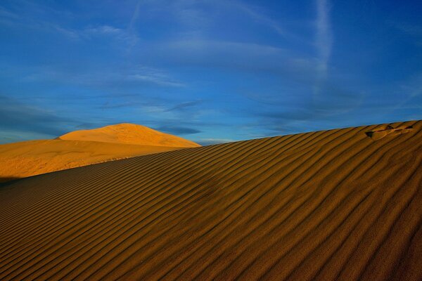 Hermoso amanecer en el desierto y alivio de la arena