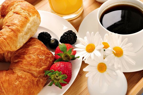 Coffee, daisies, booths and berries on a tray