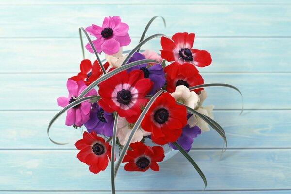 Bouquet di fiori in vaso e sul tavolo blu