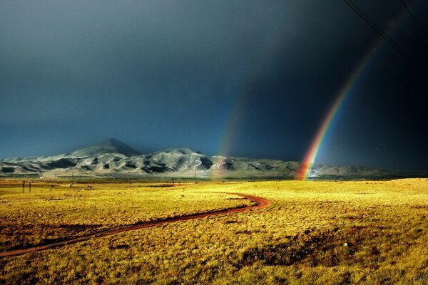 Regenbogen in der Nähe von Felsen nach Regen