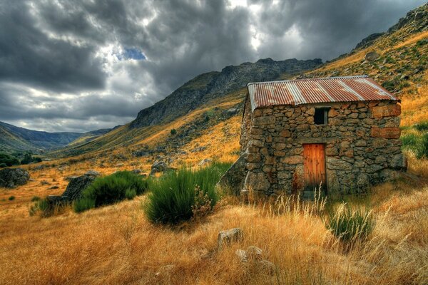 Antigua casa de piedra en la ladera de la montaña